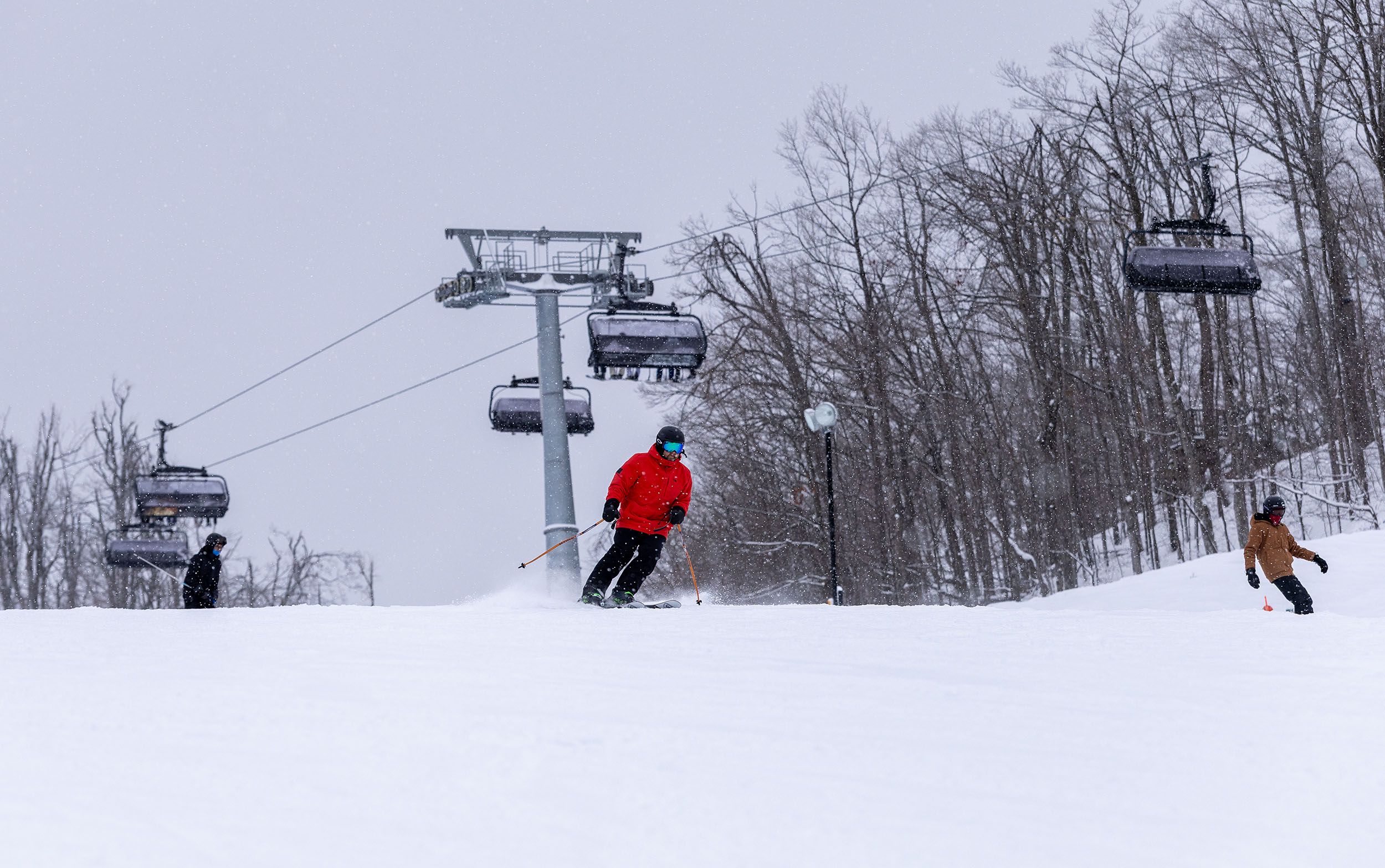 A skier in a red coat skiing by Camelot 6