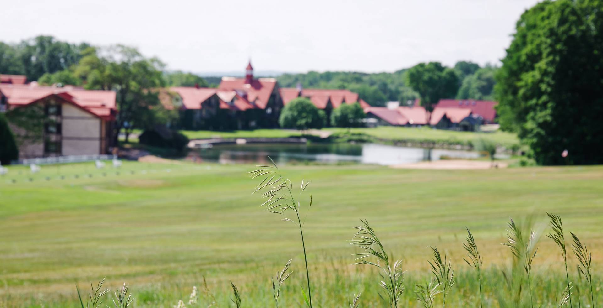 The Highlands Main Lodge exterior and pond in summer