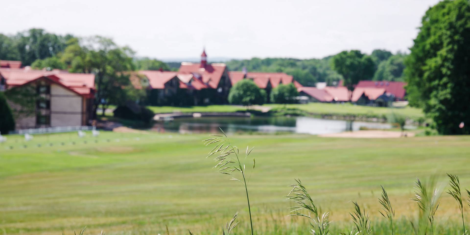 The Highlands Main Lodge exterior and pond in summer