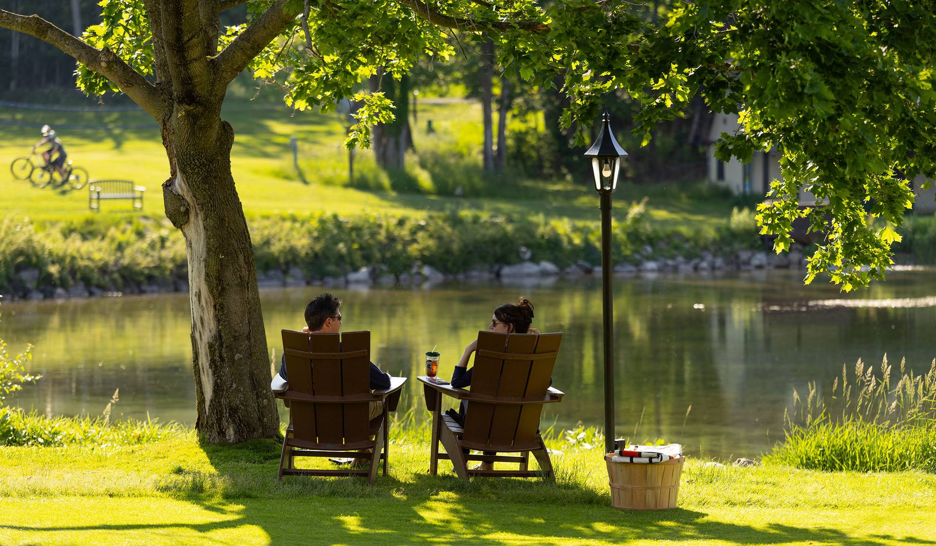 A couple sitting on chairs by the pond