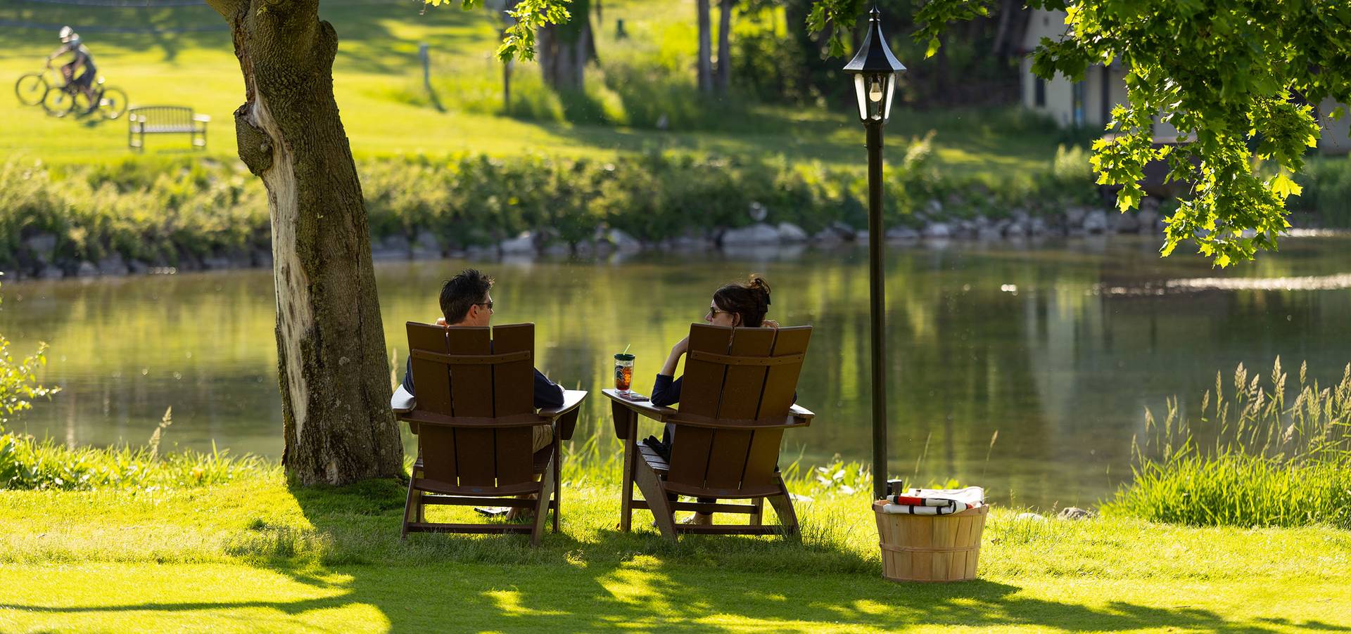A couple sitting on chairs by the pond