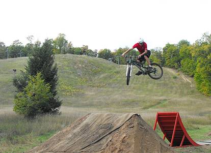 A mountain biker making a jump at the bike park