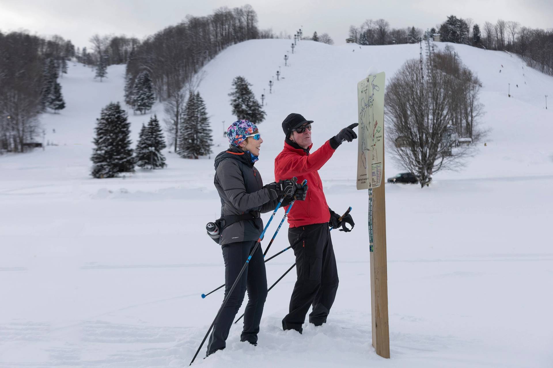 A group of cross country skiers looking at a trail map at The Highlands