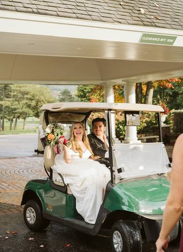 The bride and groom on a golf cart at The Highlands