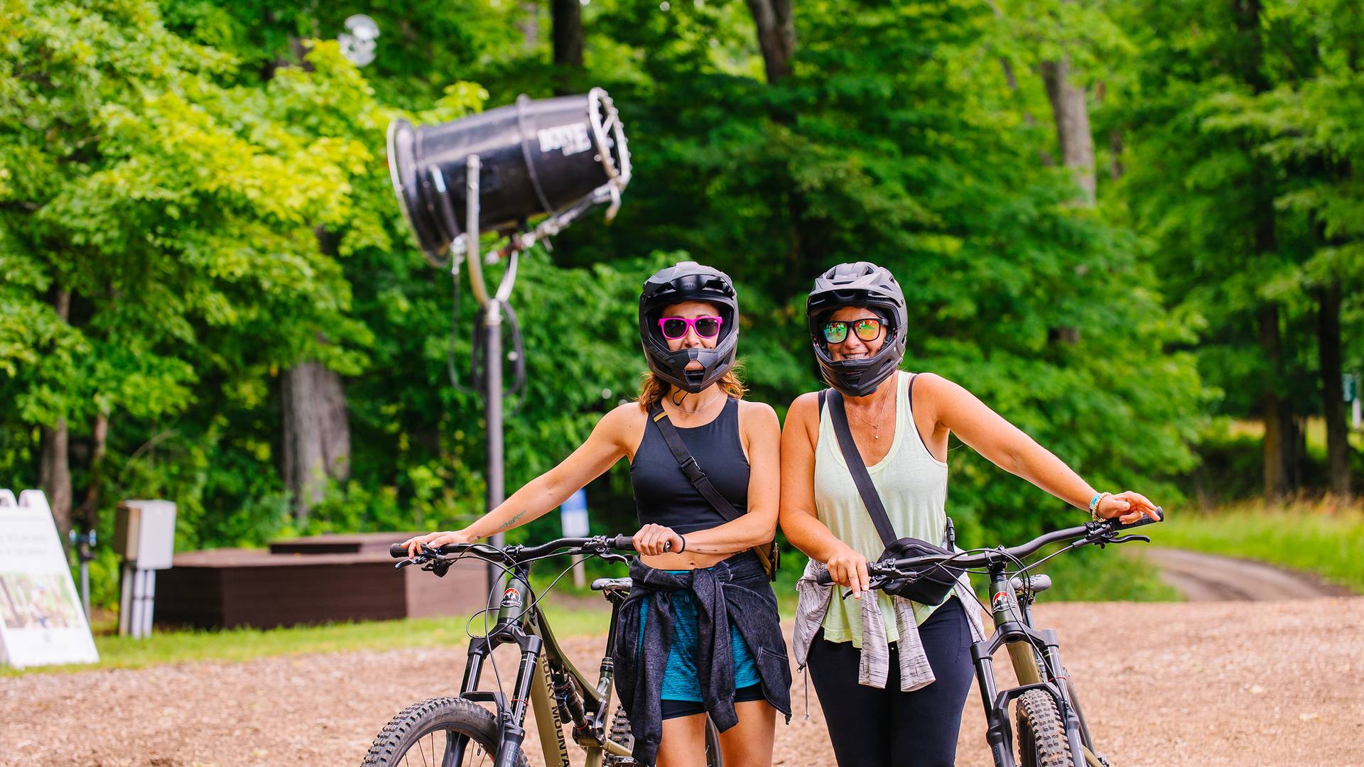 Two women posing in mountain bike gear with their bikes