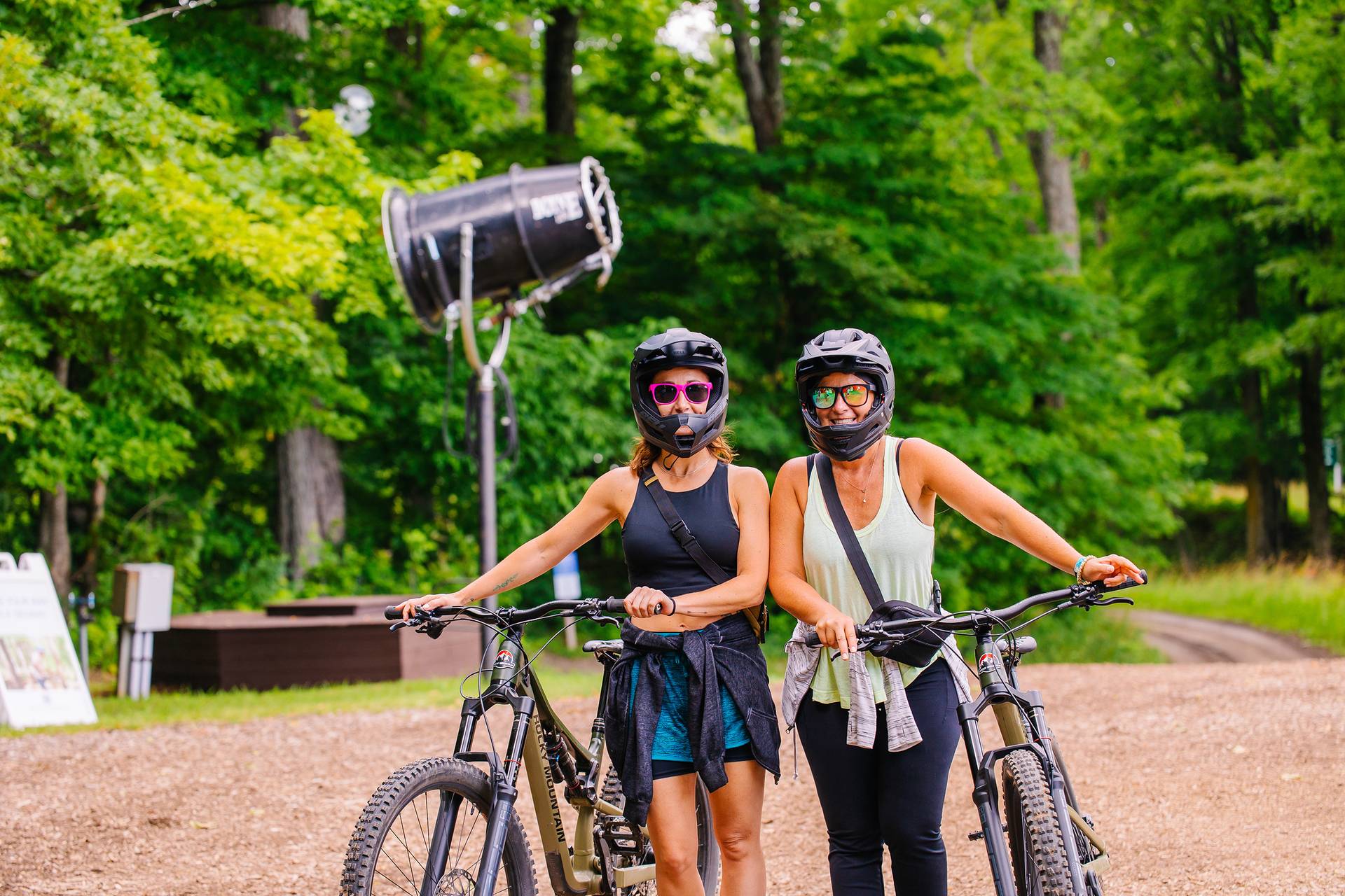 Two women posing in mountain bike gear with their bikes