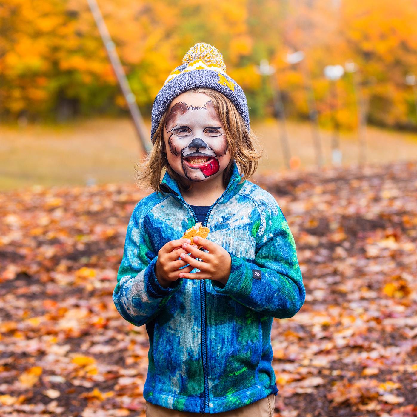 A boy smiling with his face painted during the Harvest Fest at The Highlands