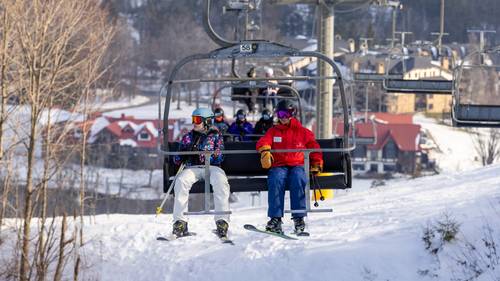 A skier and snowsports instructor on a chairlift at The Highlands