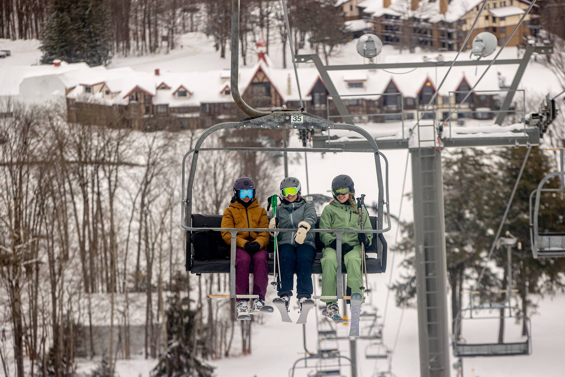 Three women in ski gear on a chairlift