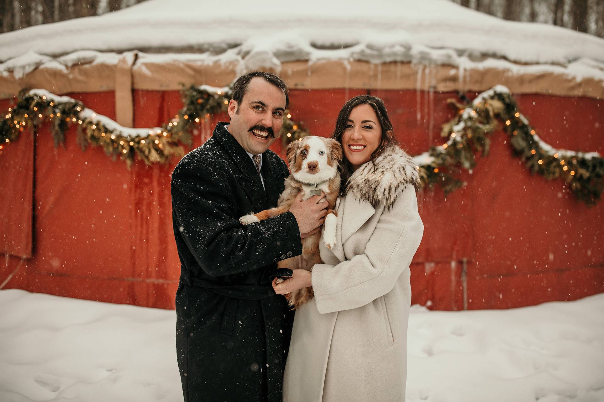 A closeup of a couple holding a dog
