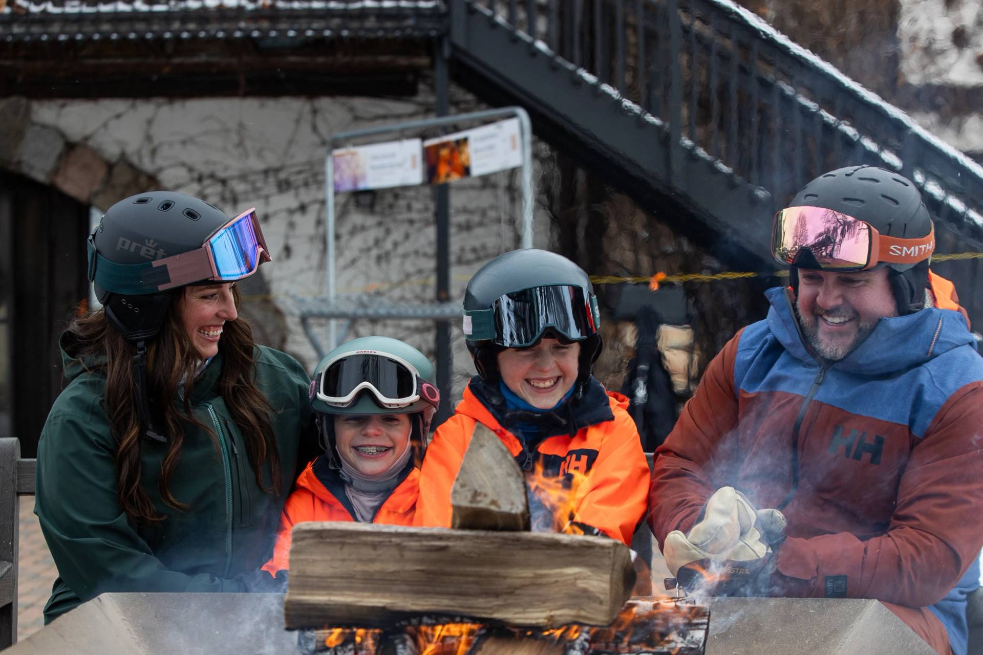 A family in ski gear by a bonfire