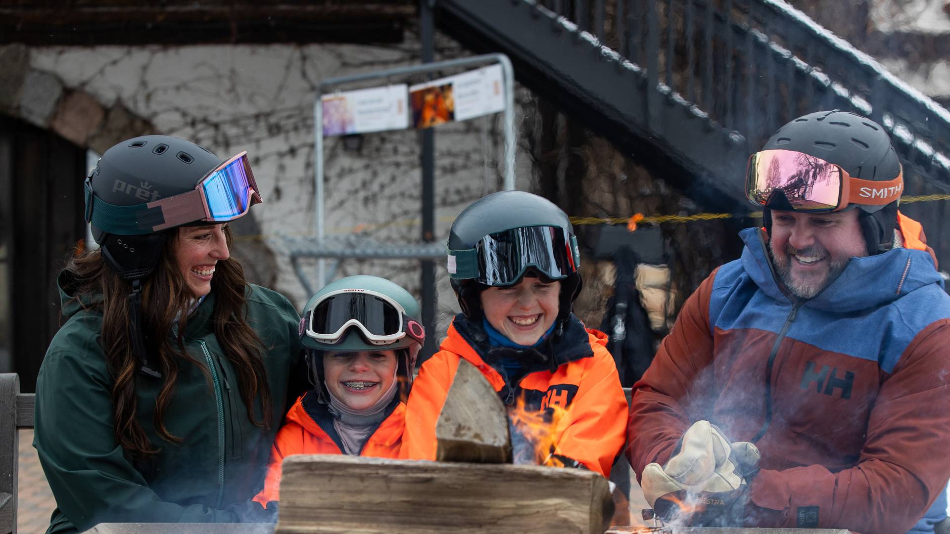 A family in ski gear by a bonfire
