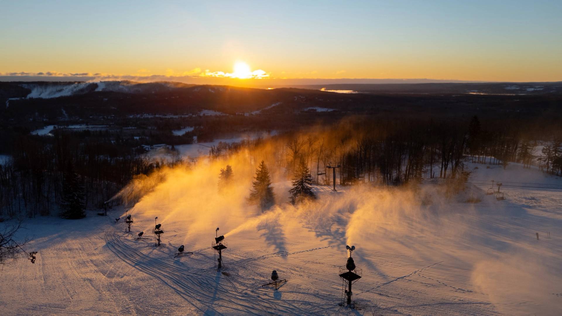 A drone shot of snowmaking during sunrise