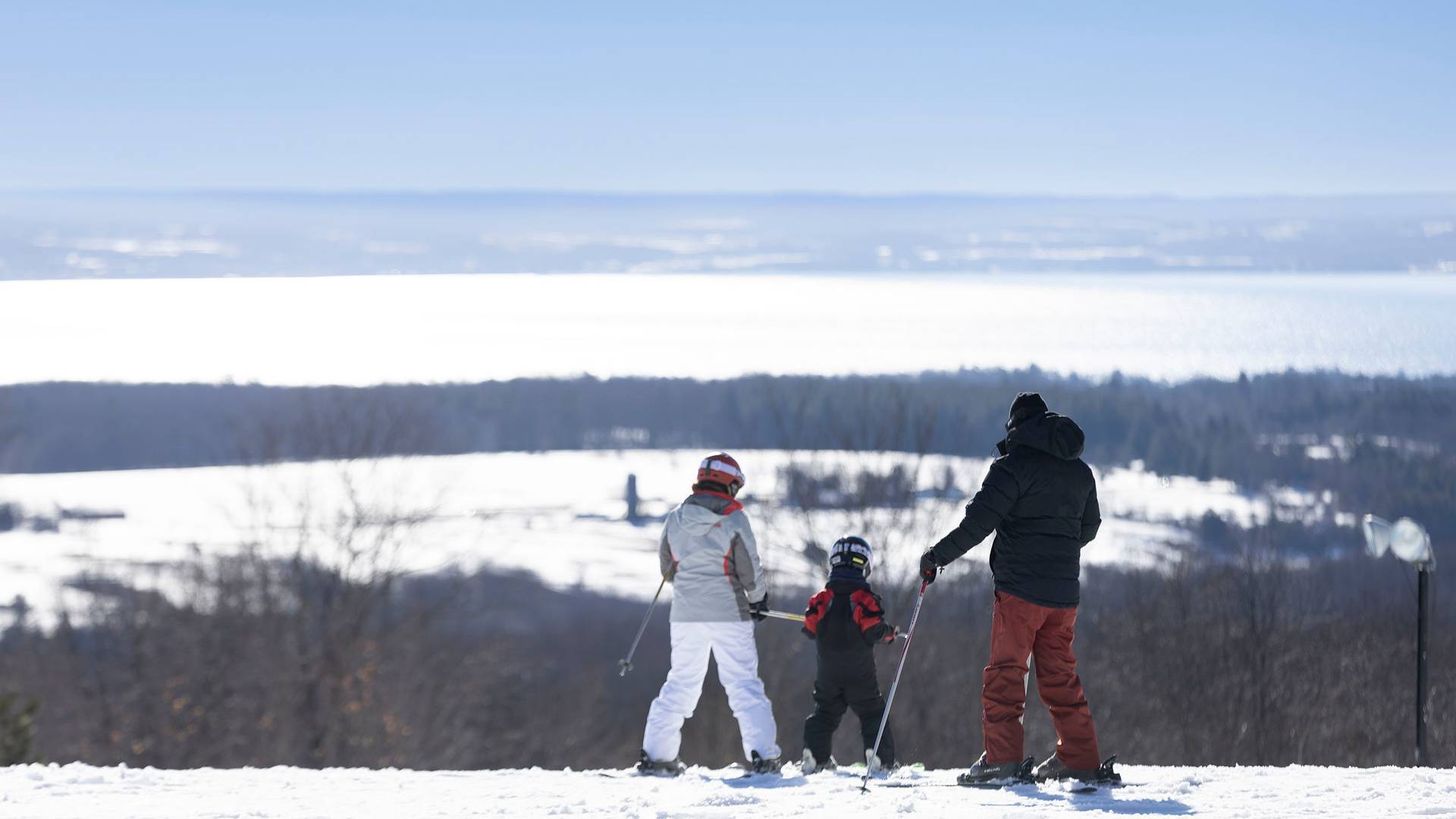 A family in ski gear taking in the view of the bay at The Highlands