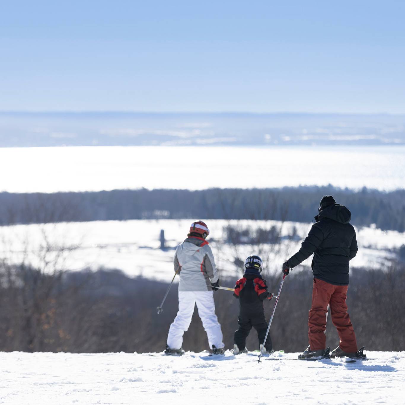 A family in ski gear taking in the view of the bay at The Highlands