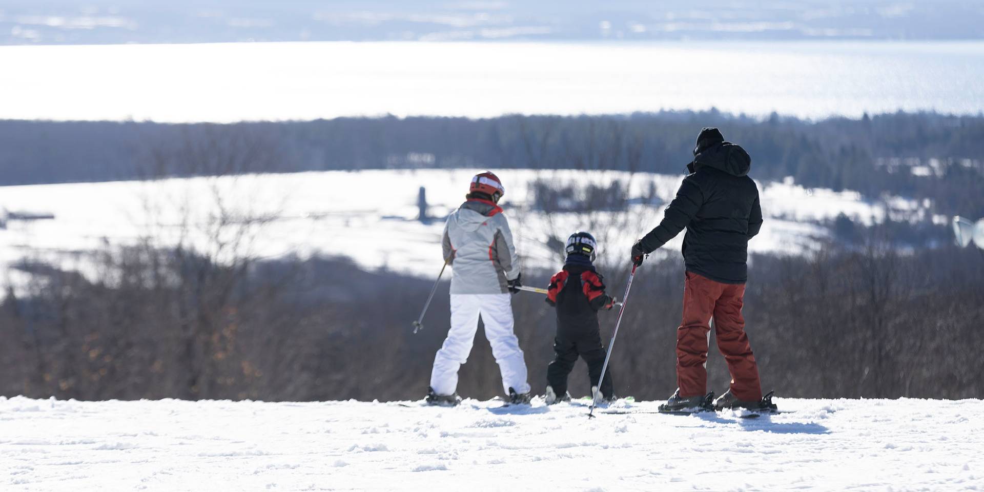 A family in ski gear taking in the view of the bay at The Highlands