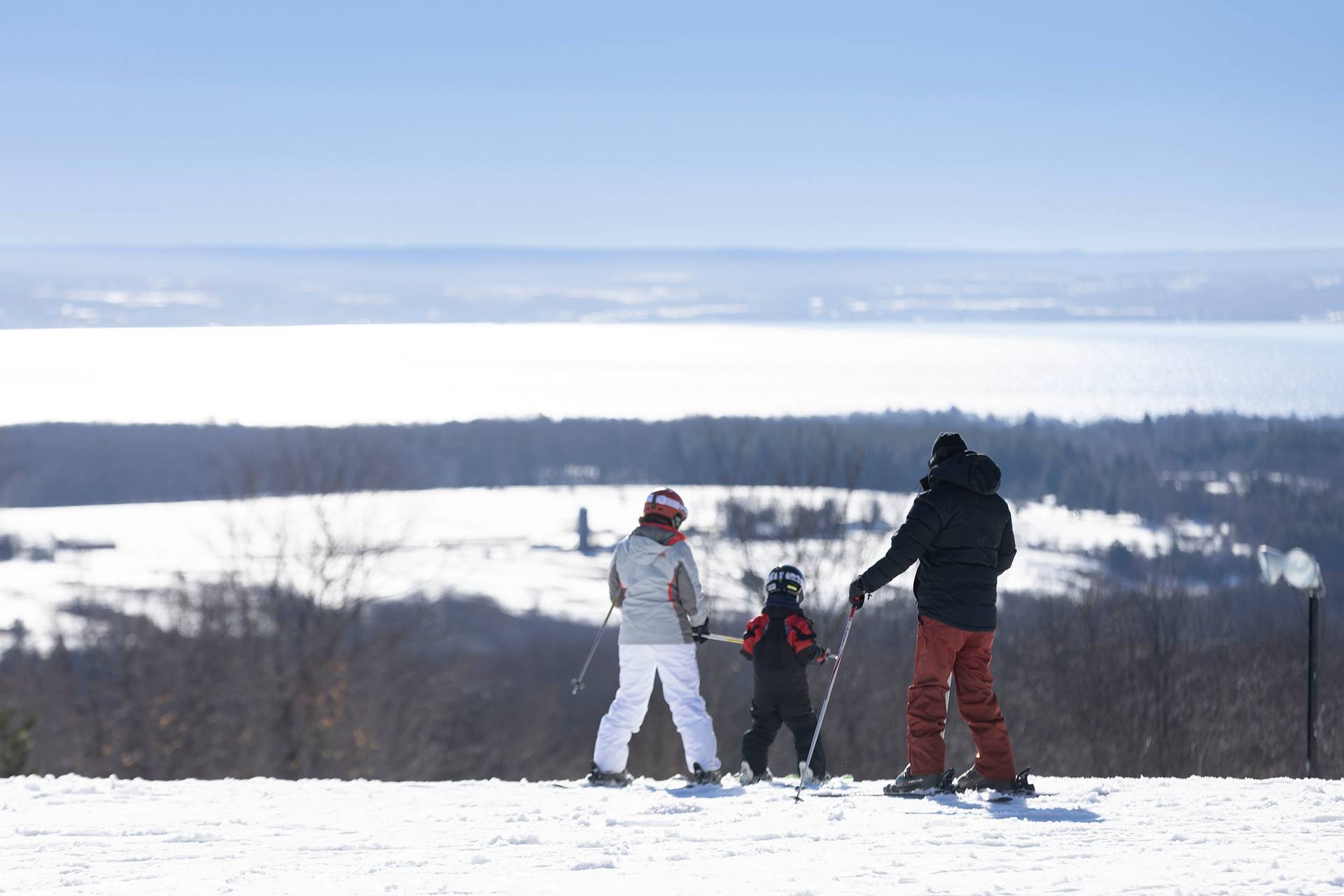 A family in ski gear taking in the view of the bay at The Highlands