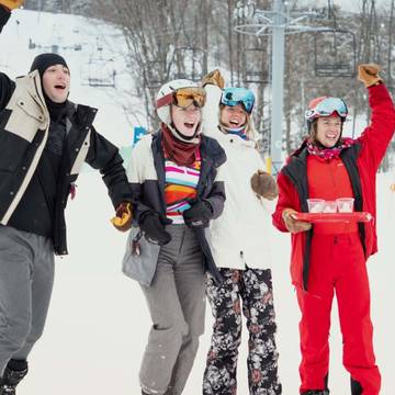 A group cheering in snow gear