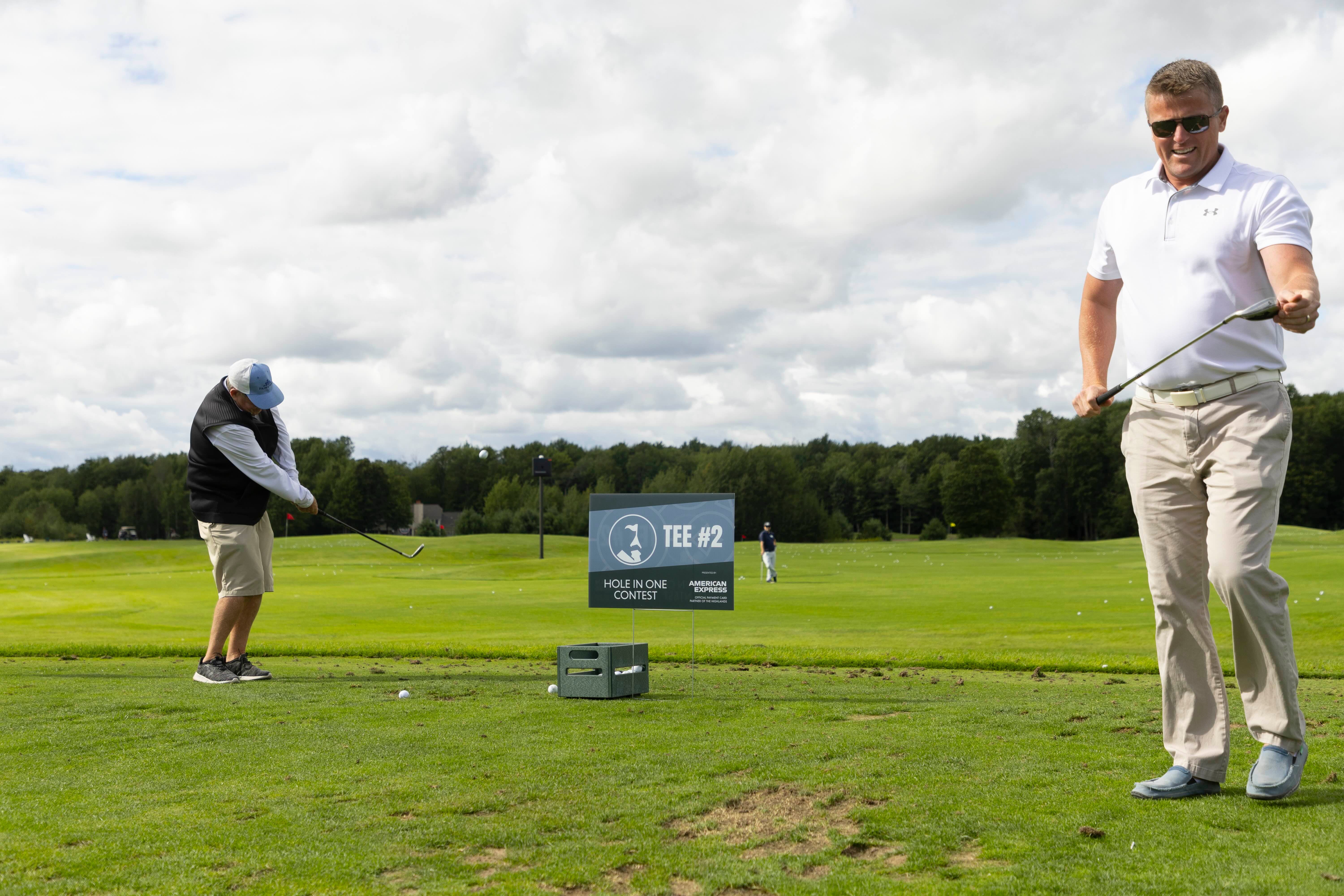 Two men golfing during a golf event at The Highlands