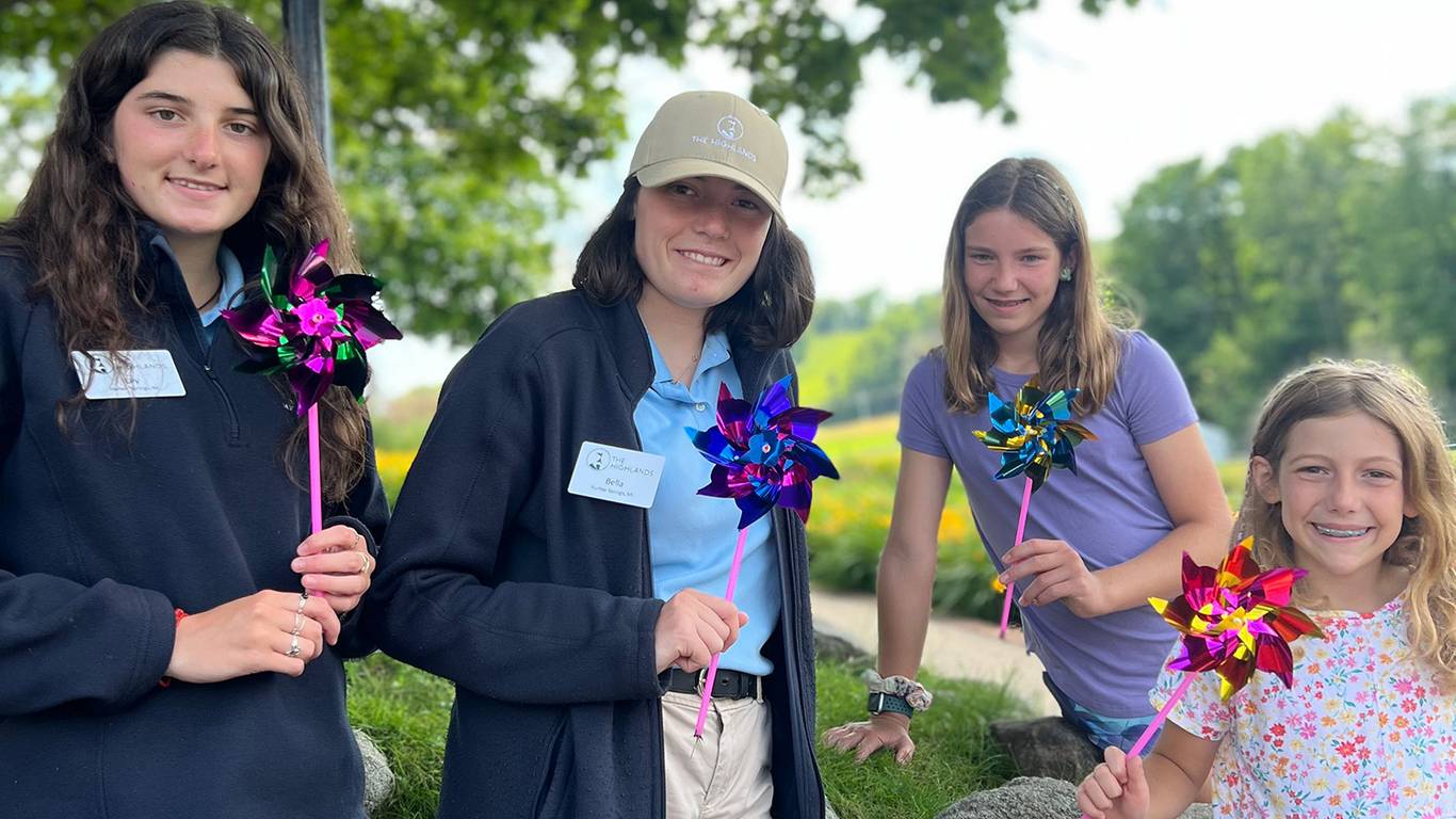 Team members and children holding pinwheel crafts