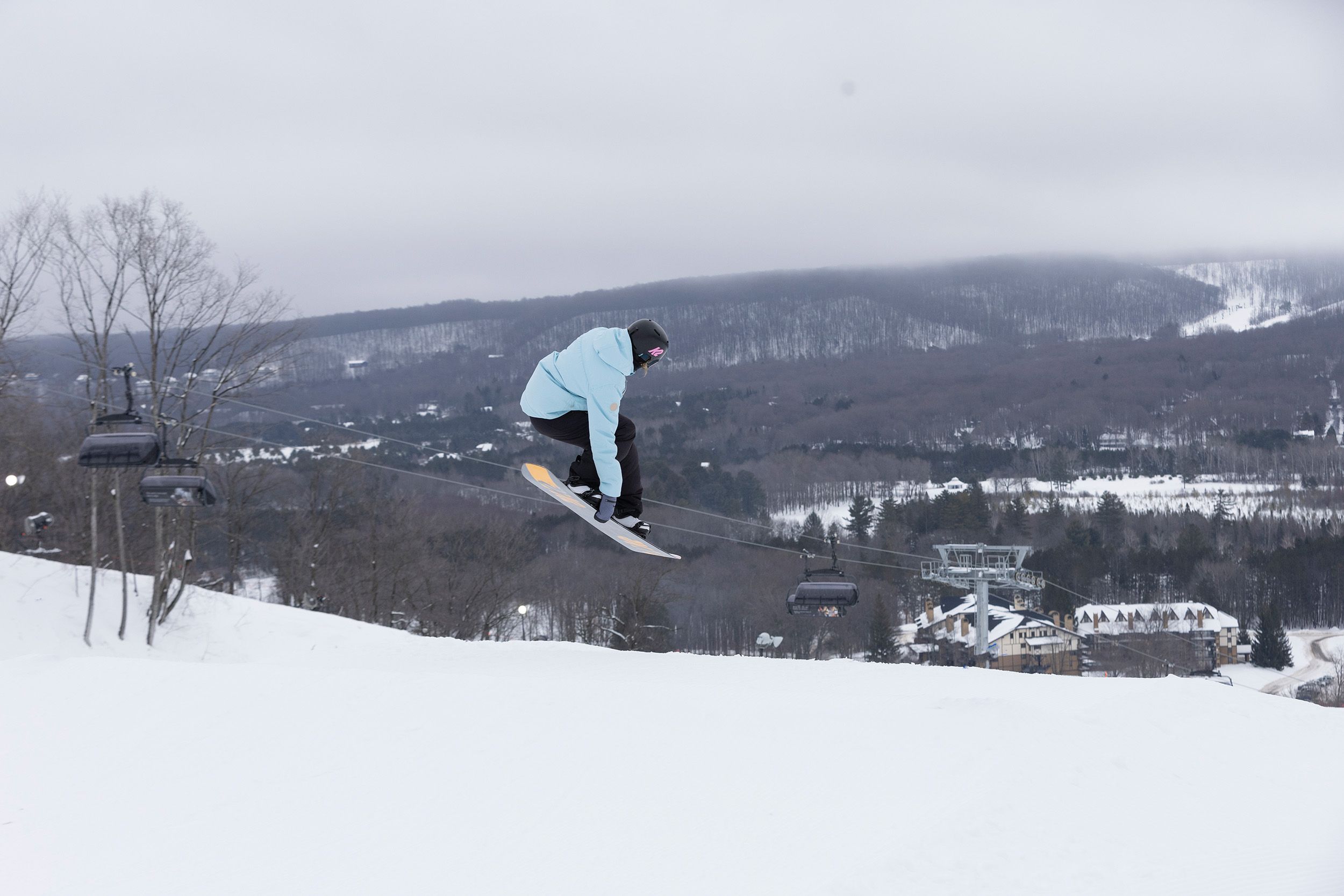 A female snowboarder doing an aerial trick at The Highlands