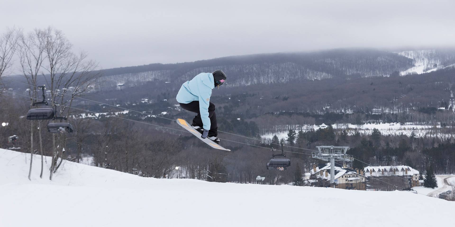 A female snowboarder doing an aerial trick at The Highlands