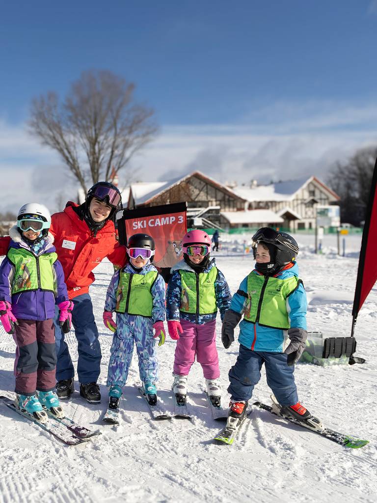 A group of ski instructors and kids smiling and posing for Ski Camp