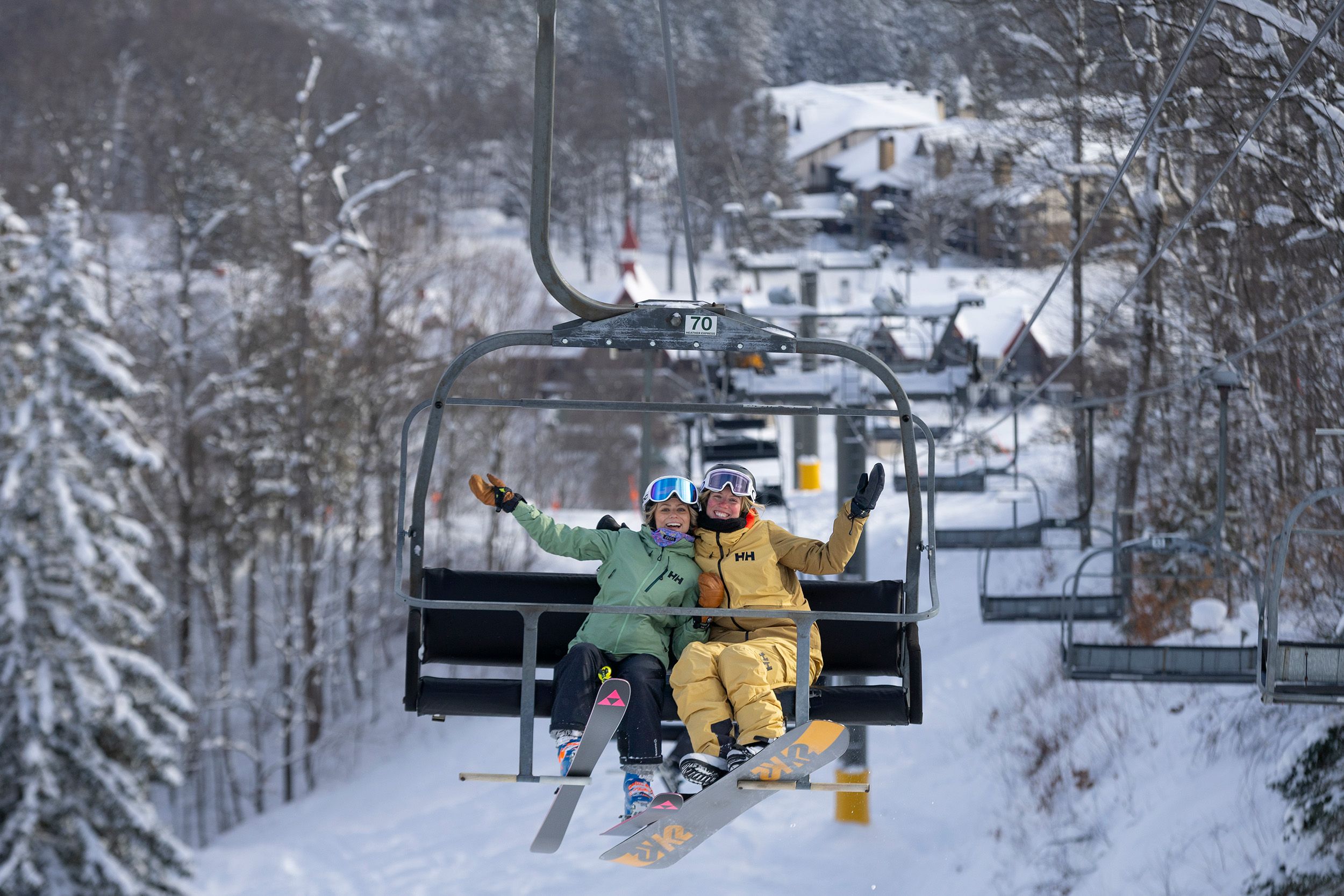Two women posing on a chairlift