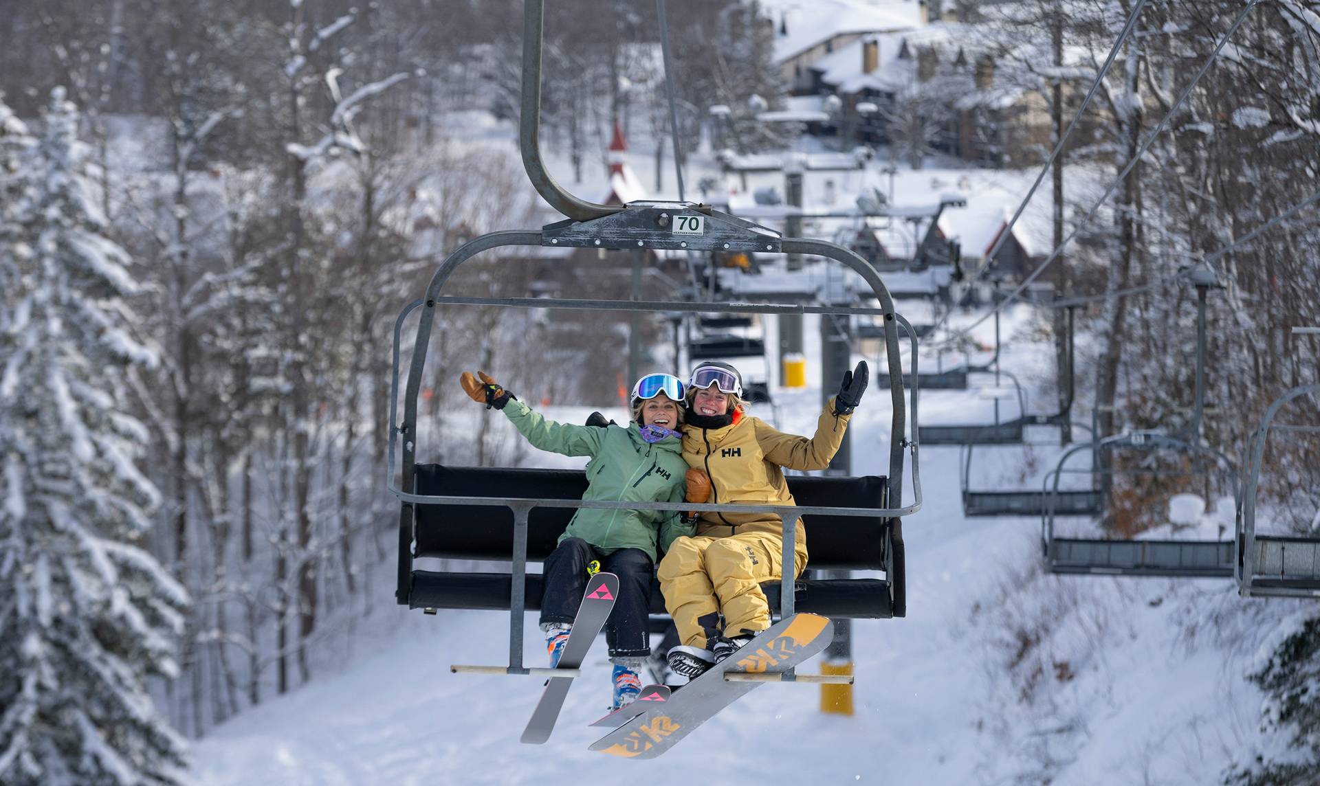 Two women posing on a chairlift
