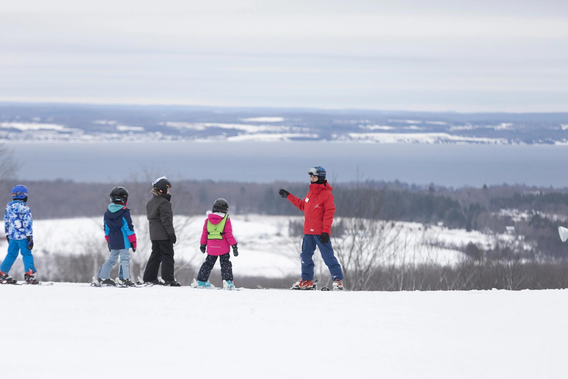 Children with their ski instructor taking a group lesson at The Highlands