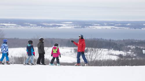 A group of snowsports instructors with kids at The Highlands