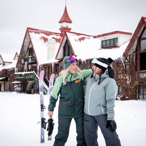 Two women posing and smiling in ski gear at The Highlands