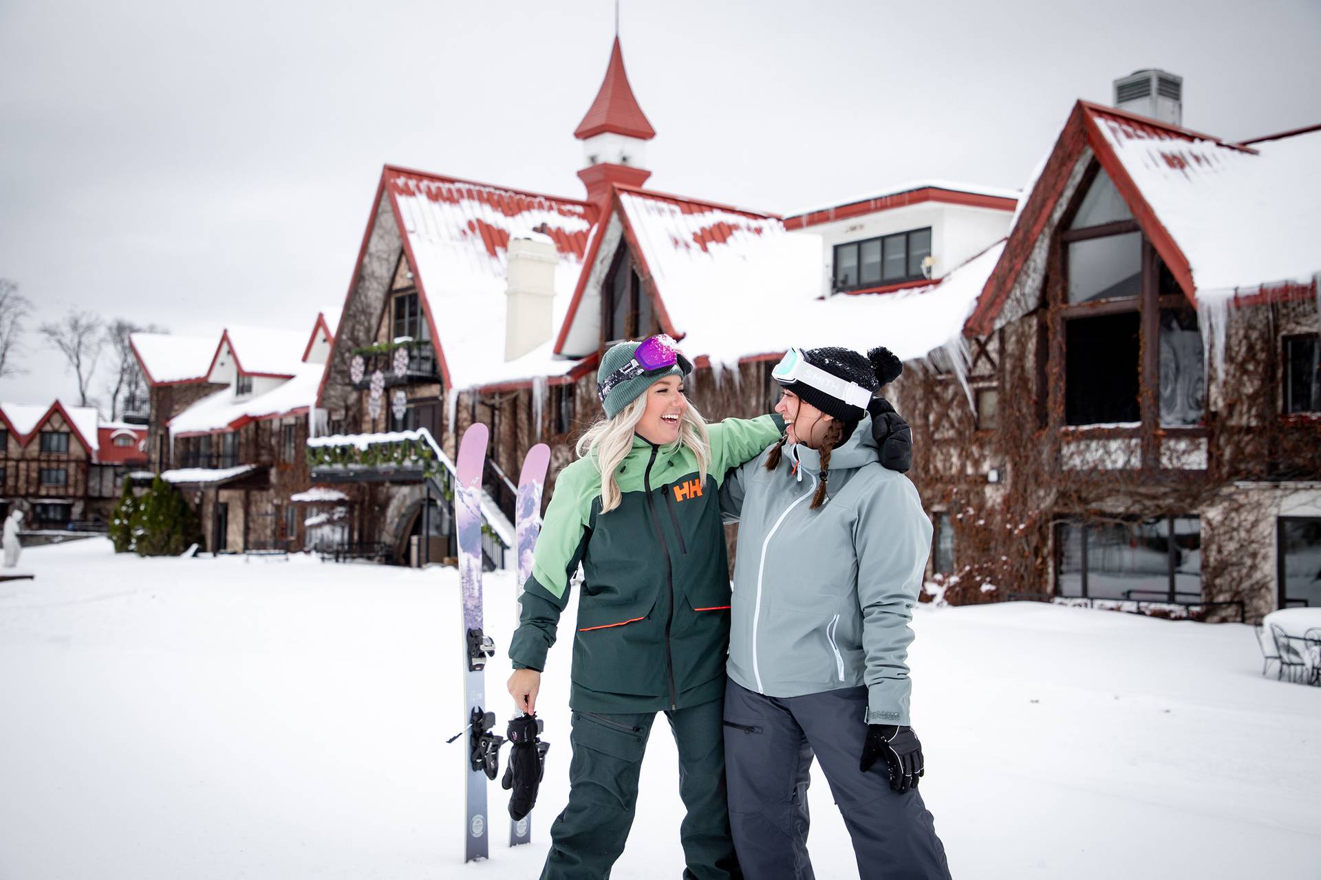 Two women posing and smiling in ski gear at The Highlands