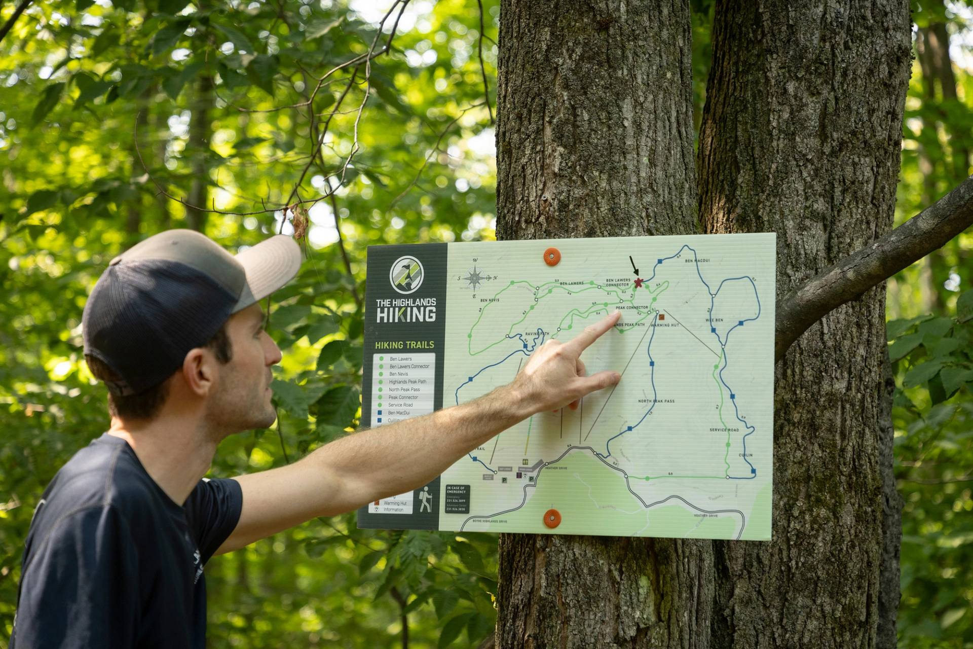 A man pointing to a hiking trail map at The Highlands