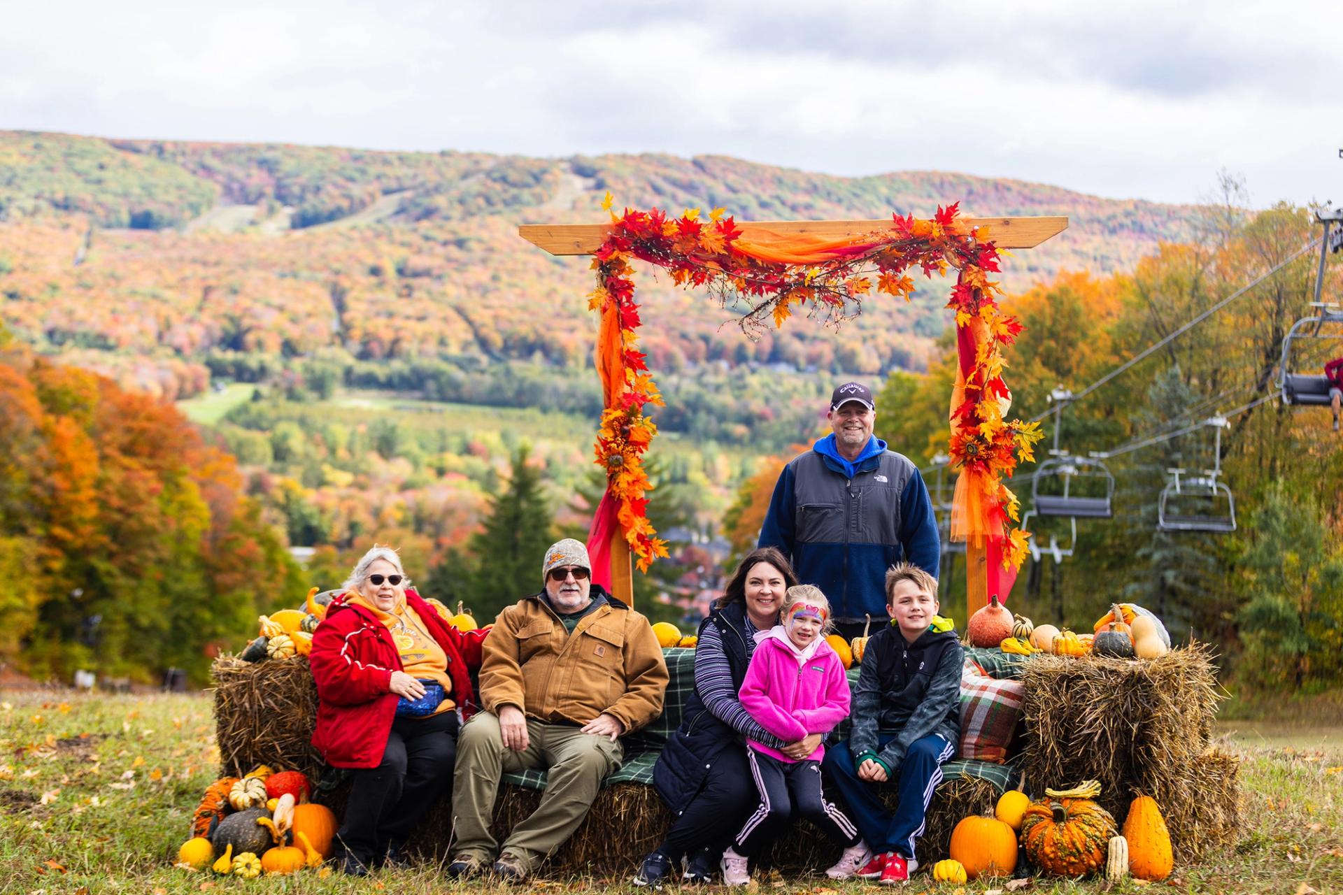 A group posing on hay bales during the Harvest Fest at The Highlands