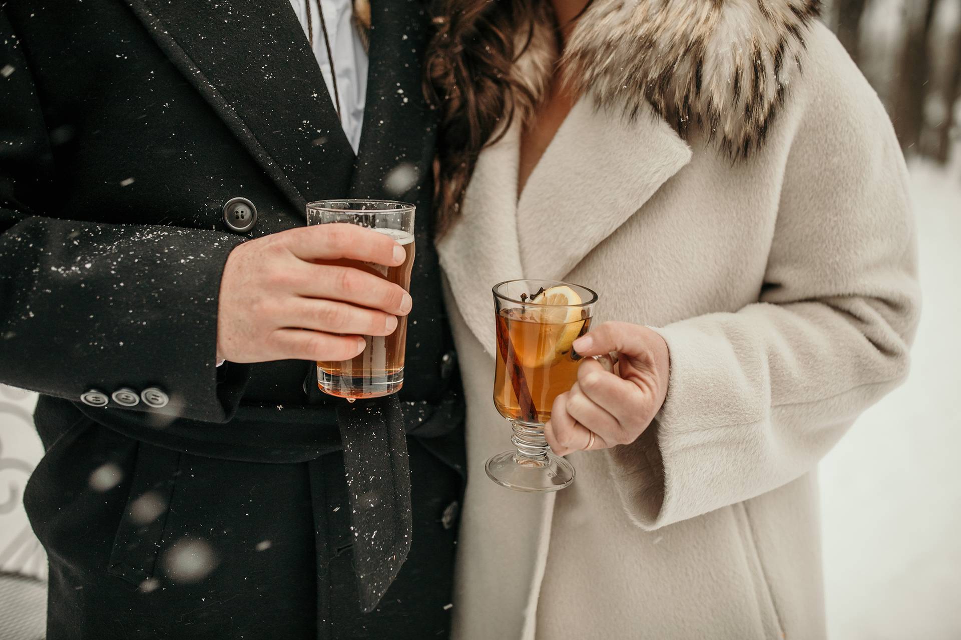 A closeup of hands holding cocktails