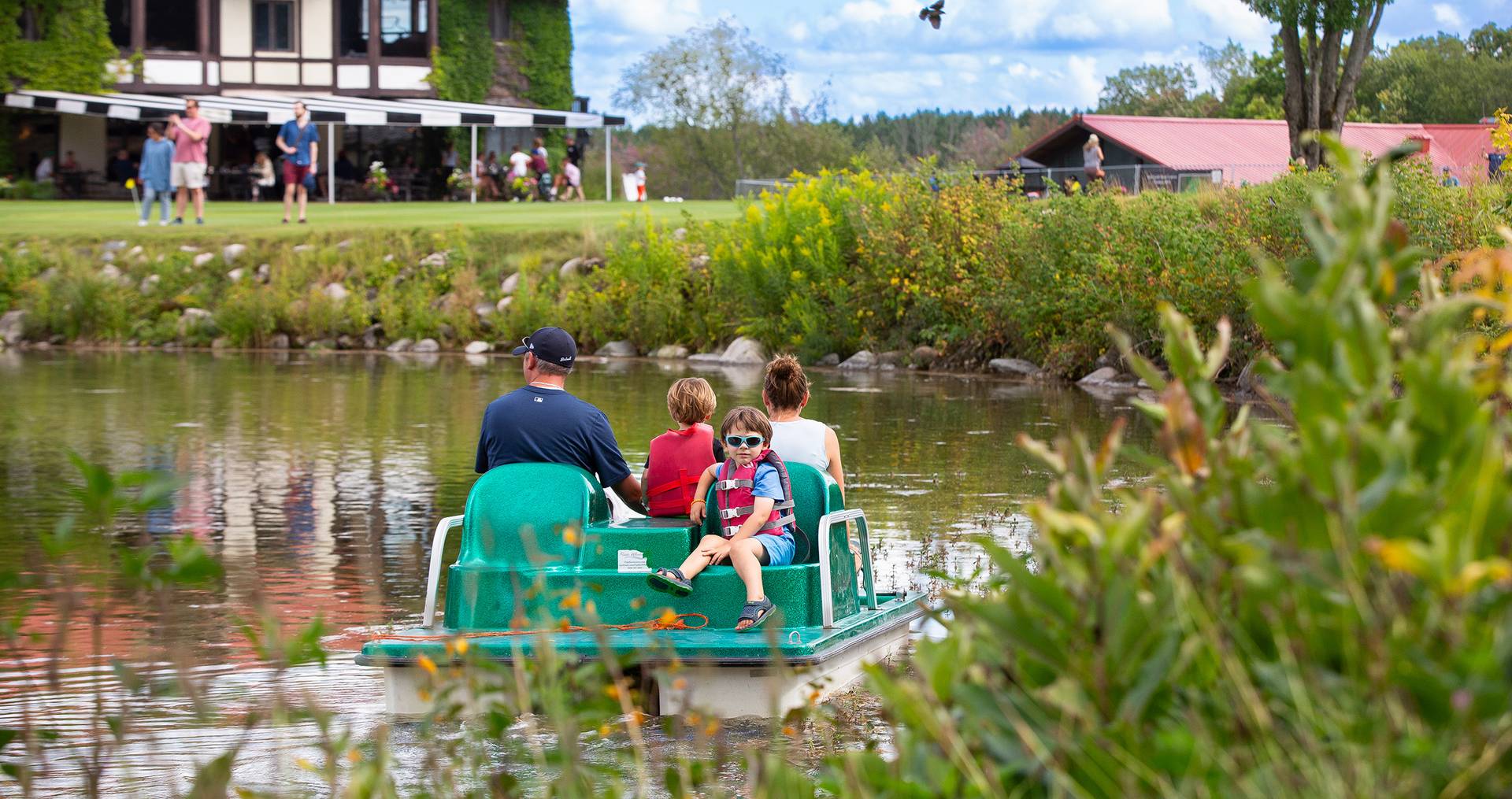 A family on a pedal boat in the pond