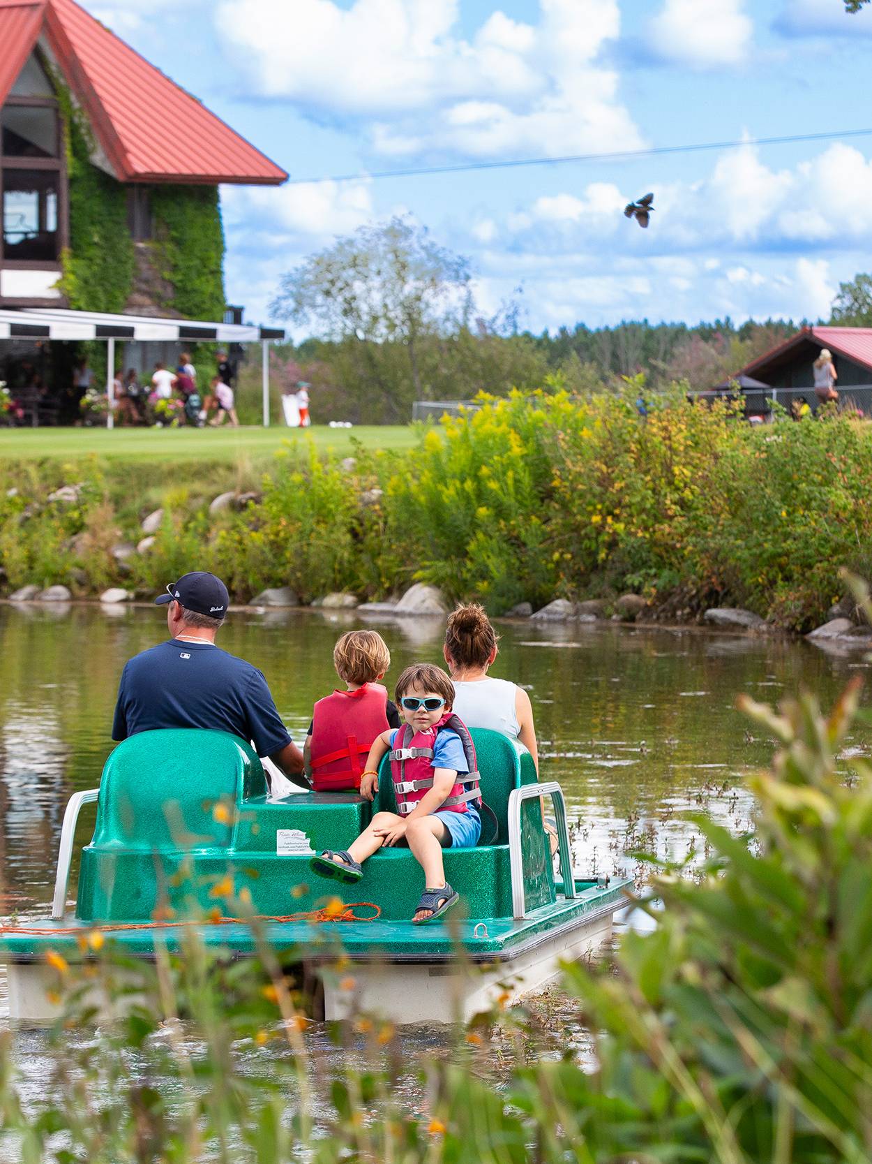 A family on a pedal boat in the pond