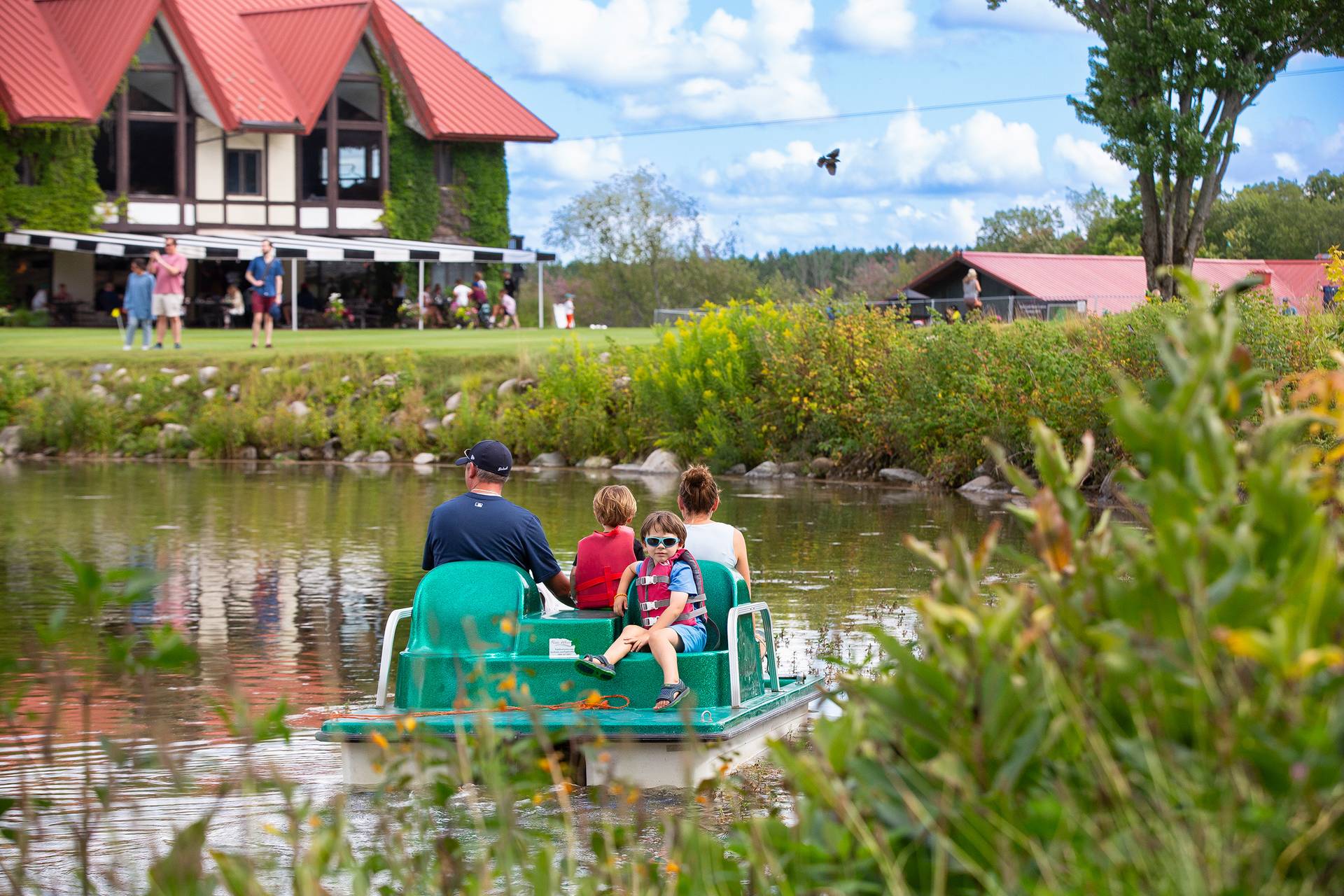 A family on a pedal boat in the pond