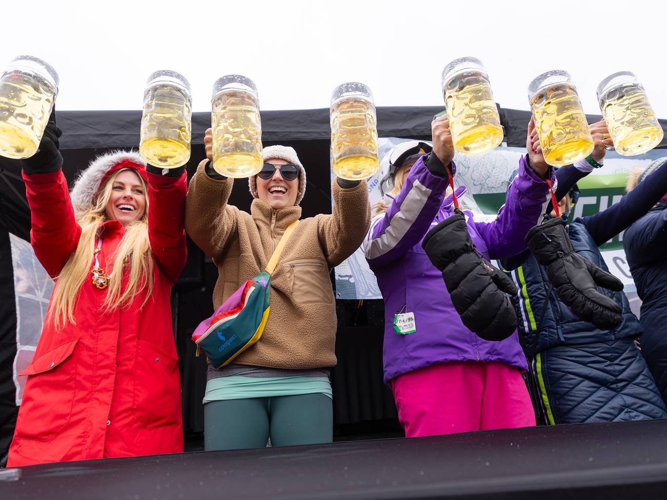 A group of women holding steins of beer