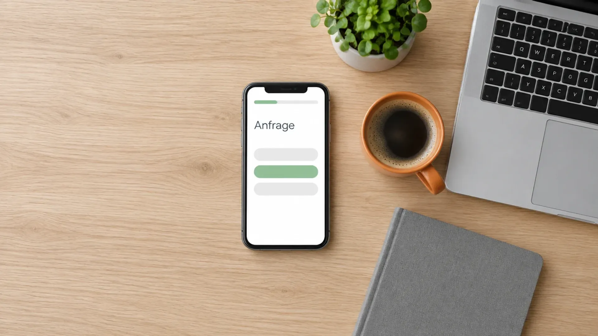 Smartphone mit einem Anfrage-Formular und Fortschrittsbalken auf einem hellen Holztisch neben Laptop, Kaffeetasse und Pflanze