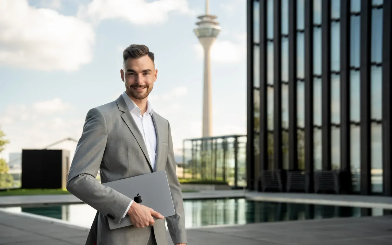 Jan Philipps im Sakko mit Laptop im Düsseldorfer Medienhafen
