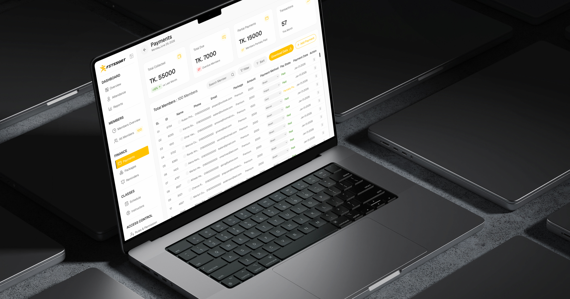 A MacBook on a dark desk showing the FitSSort payments table