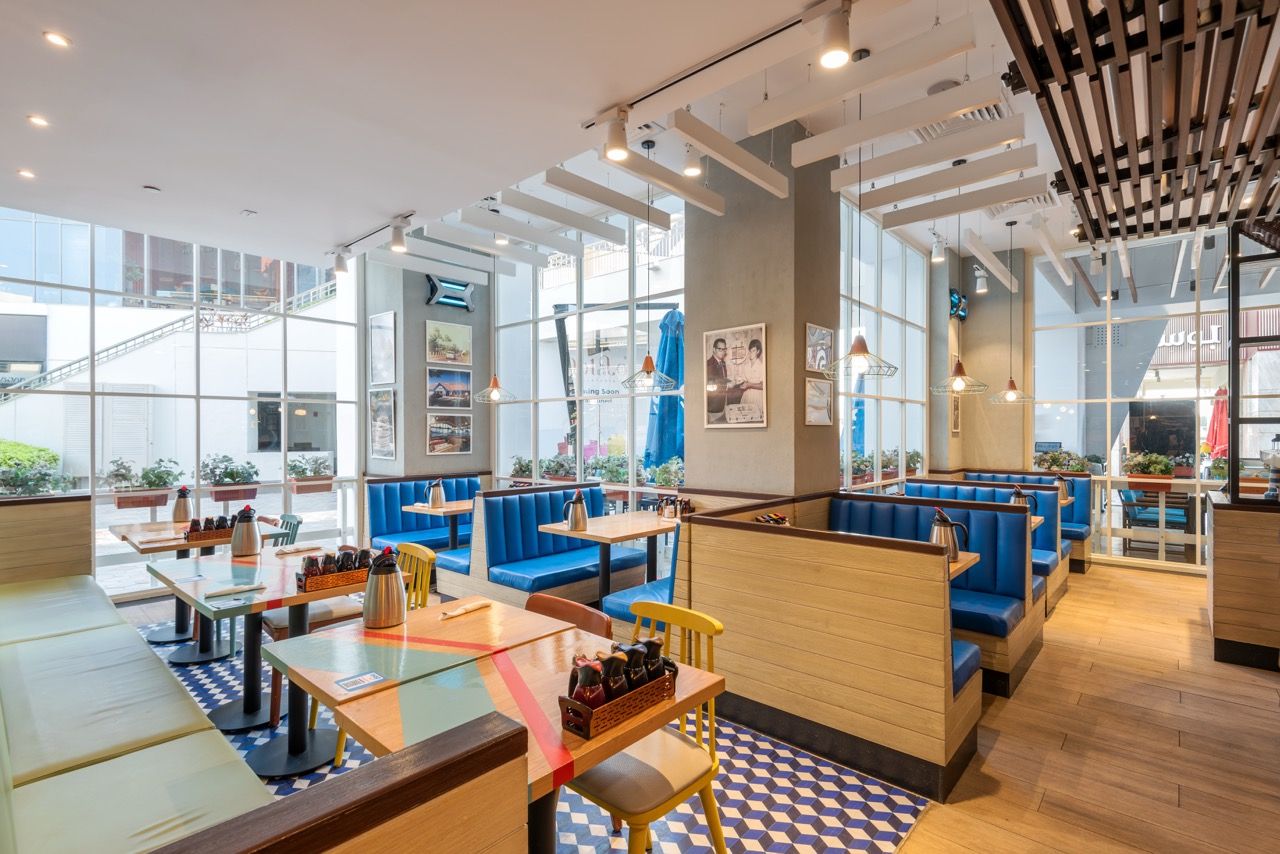 A wide-angle, exterior view of the **Lloyd's Building** in London, showcasing its distinctive inside-out architecture with exposed pipes, ducts, and service elements on the facade. The building stands tall against the skyline, reflecting the surrounding urban environment.