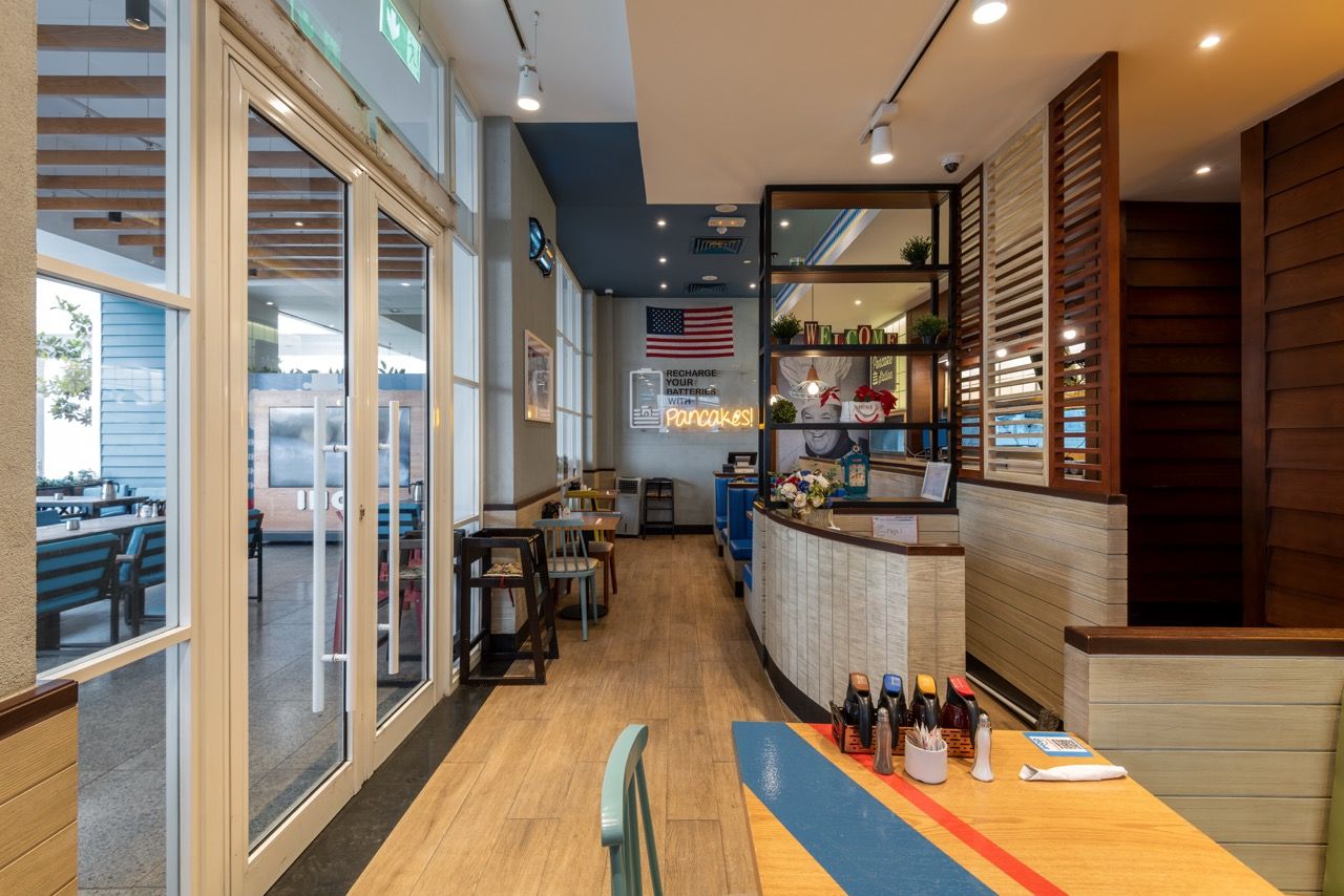 A wide-angle, exterior view of the **Lloyd's Building** in London, showcasing its distinctive inside-out architecture with exposed pipes, ducts, and service elements on the facade. The building stands tall against the skyline, reflecting the surrounding urban environment.