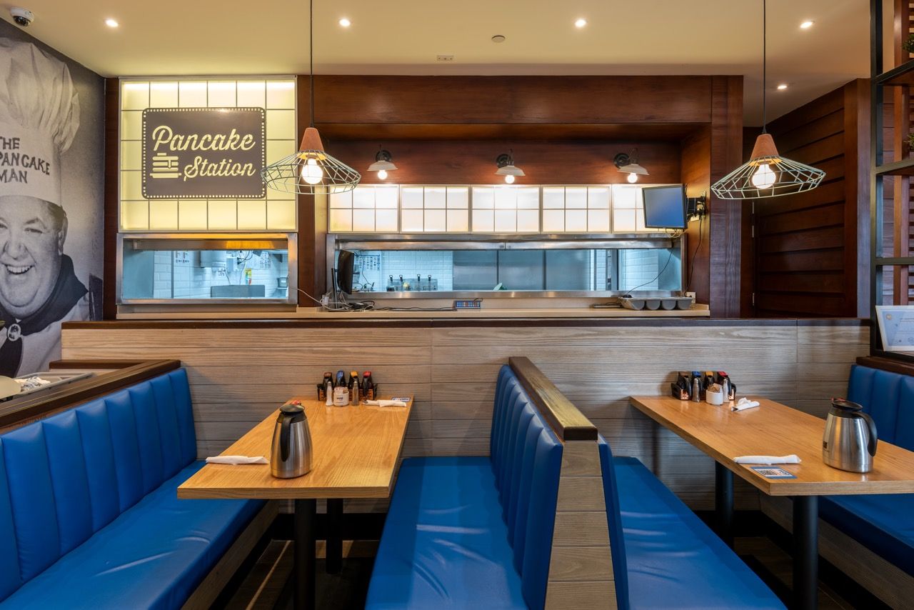 A wide-angle, exterior view of the **Lloyd's Building** in London, showcasing its distinctive inside-out architecture with exposed pipes, ducts, and service elements on the facade. The building stands tall against the skyline, reflecting the surrounding urban environment.