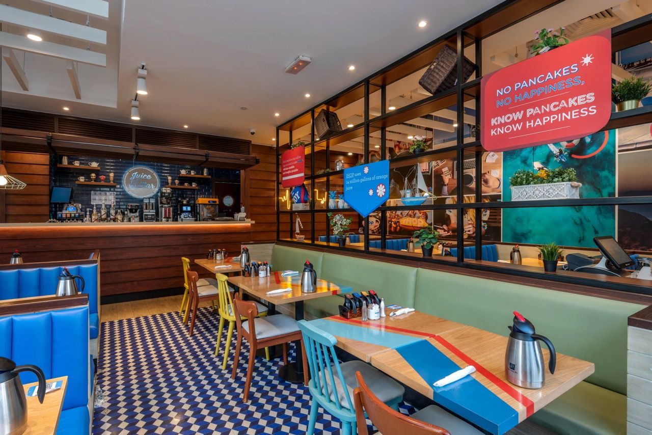 A wide-angle, exterior view of the **Lloyd's Building** in London, showcasing its distinctive inside-out architecture with exposed pipes, ducts, and service elements on the facade. The building stands tall against the skyline, reflecting the surrounding urban environment.