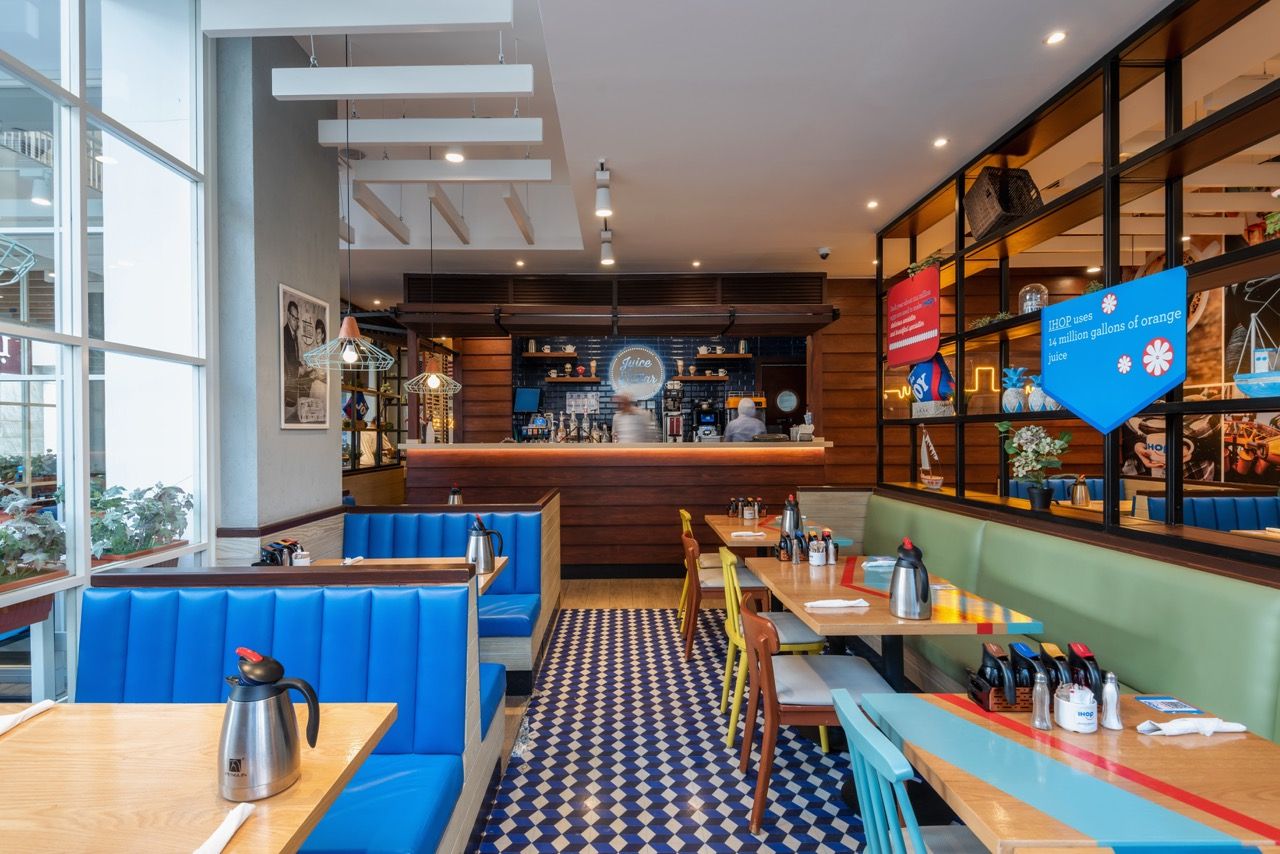 A wide-angle, exterior view of the **Lloyd's Building** in London, showcasing its distinctive inside-out architecture with exposed pipes, ducts, and service elements on the facade. The building stands tall against the skyline, reflecting the surrounding urban environment.
