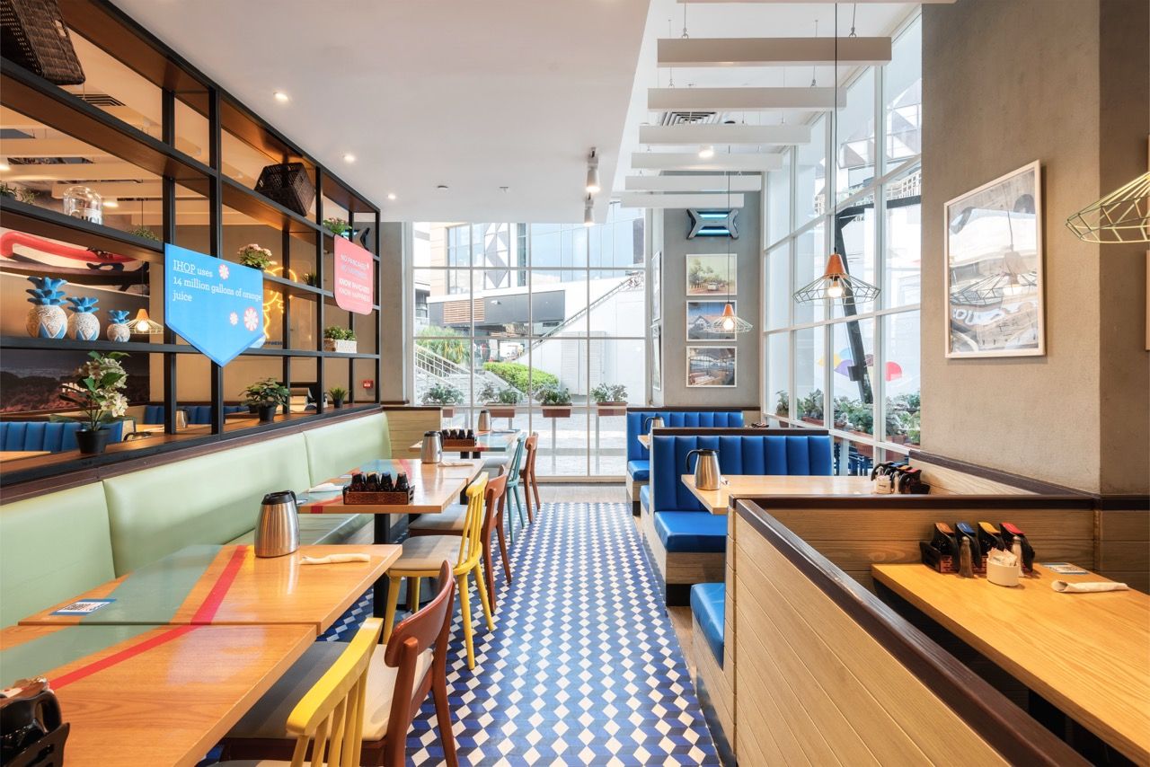 A wide-angle, exterior view of the **Lloyd's Building** in London, showcasing its distinctive inside-out architecture with exposed pipes, ducts, and service elements on the facade. The building stands tall against the skyline, reflecting the surrounding urban environment.