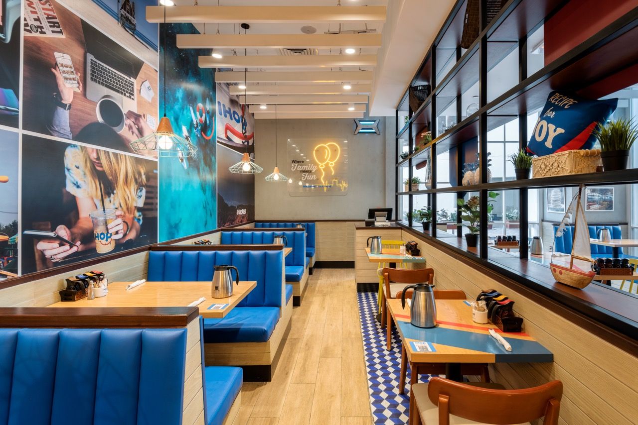 A wide-angle, exterior view of the **Lloyd's Building** in London, showcasing its distinctive inside-out architecture with exposed pipes, ducts, and service elements on the facade. The building stands tall against the skyline, reflecting the surrounding urban environment.